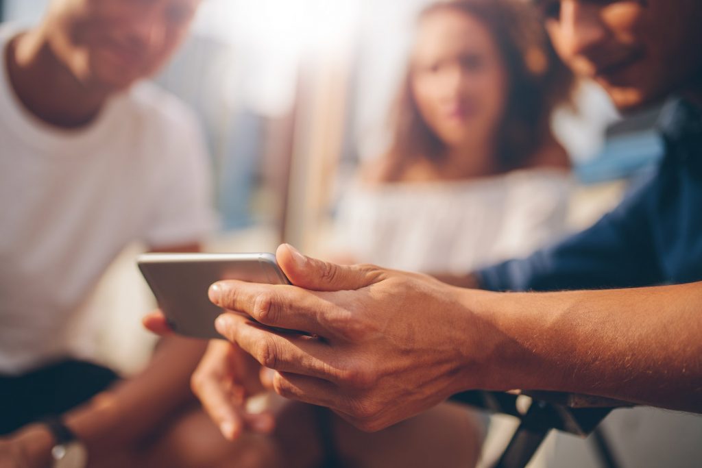 Man Showing a Video on His Phone to Friends